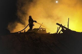 Une photo mise à disposition par l'administration militaire régionale de Khmelnytskyi montre des sauveteurs ukrainiens éteignant un incendie dans un entrepôt de déchets de maïs après un bombardement près de Starokostiantyniv, dans la région de Khm...